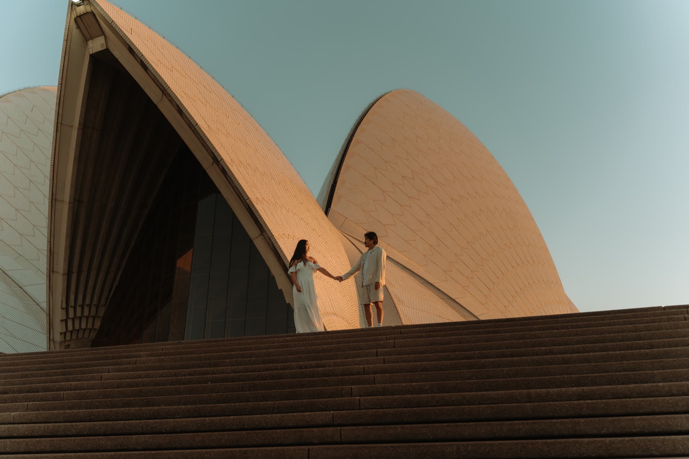 Stephanie and Terence holding hands on the steps of the Sydney Opera House